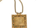 a gold pendant with a picture of a man and a woman on it