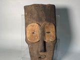 gros plan d'un masque en bois sur une surface blanche