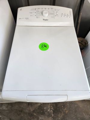 un lave-linge et un sèche-linge blancs dans un garage, sur lesquels est apposé un autocollant vert