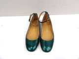 green leather shoes with buckles on the toes