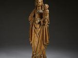 une statue en bois représentant une femme tenant un enfant dans ses bras
