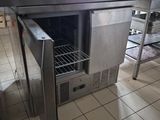 une table en acier inoxydable avec une porte ouverte dans une cuisine
