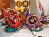 three figurines of fish on a table next to a coffee cup