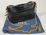 le sac à main noir est posé sur un tissu bleu