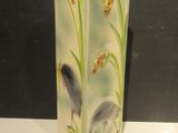 a vase with a bird on it sitting on a table