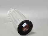 a small glass bottle with a black lid on a white surface