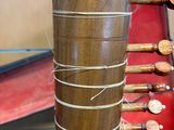 a tall wooden vase with a bunch of wooden spoons in it