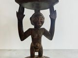 statue en bois représentant un homme tenant un plateau sur la tête