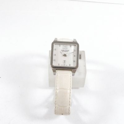 une montre-bracelet blanche avec un bracelet blanc posée sur une surface blanche