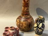 trois vases posés l'un à côté de l'autre sur une table