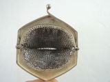 someone is holding a silver purse with a mesh inside of it