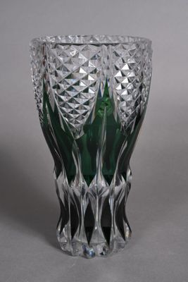 a green glass vase sitting on top of a table