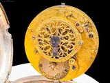 a close up of a gold pocket watch with a black background