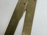 a pair of brass rulers on a white surface