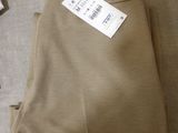 a pair of pants on the floor with a price tag on it