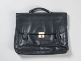 porte-documents en cuir noir avec des finitions en laiton sur fond blanc