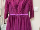 a purple dress hanging on a hanger in a room