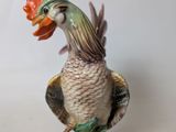 a figurine of a rooster with a flower on it ' s head