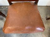 a brown chair that has a brown seat on it