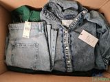 a cardboard box filled with jeans and a jacket