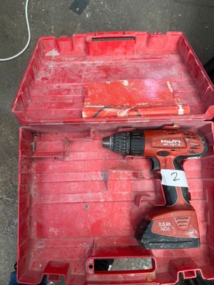 a red tool box with a drill in it on the ground
