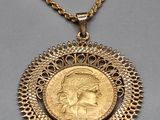 a gold coin pendant with a woman ' s face on it