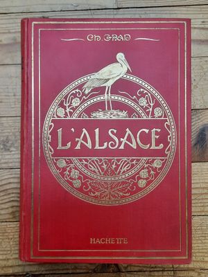 un livre rouge posé sur une table en bois