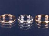 trois bagues en or et en argent serties de diamants sur un fond noir