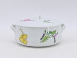 a white casserole with fruit on it on a white surface