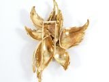 a gold flower brooch on a white surface