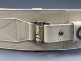 the belt is white and has a metal buckle on it