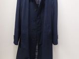 the coat is hanging on a hanger on the wall