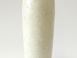 un vase blanc posé sur une surface blanche