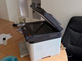 a black and white printer sitting on a desk next to a chair