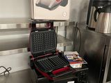 a laptop and a coffee maker sitting on a table