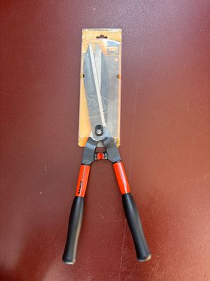 a pair of pliers on the wall next to a pair of scissors