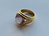 an image of a gold ring with a purple stone on it