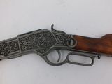 a close up of a rifle on a table with a white background