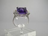 une bague en améthorate et diamant posée sur un présentoir transparent