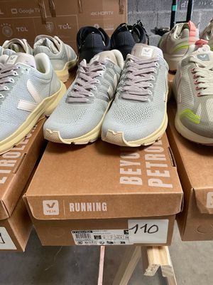 several pairs of running shoes sitting on top of boxes in a store
