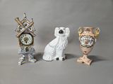 three figurines of dogs and a clock on a table
