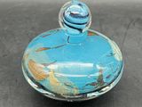 a small glass jar with a blue lid on a table