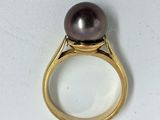 un gros plan d'une bague ornée d'une perle noire