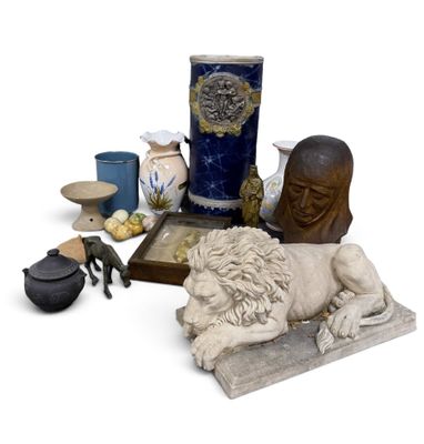 a statue of a man laying on a table next to other items