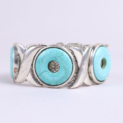 un gros plan d'une bague ornée de deux yeux en turquoise