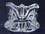 a close up of a clear glass candle holder on a blue background