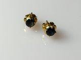 a pair of black diamond stud earrings on a white surface