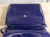 a blue purse sitting on top of a wooden table