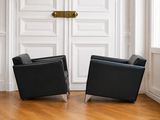 deux fauteuils en cuir noir placés devant une porte blanche
