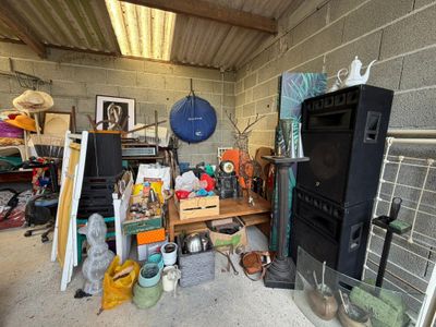 une photo d'un garage encombré où l'on voit un téléviseur et d'autres objets